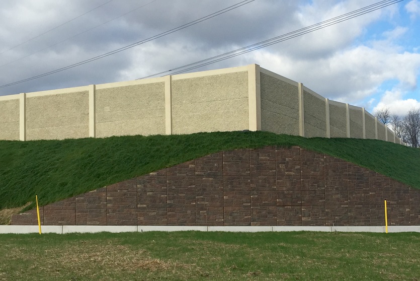 The T-Wall precast modular retaining wall by Geoquest pictured completed on-site above an embankment.