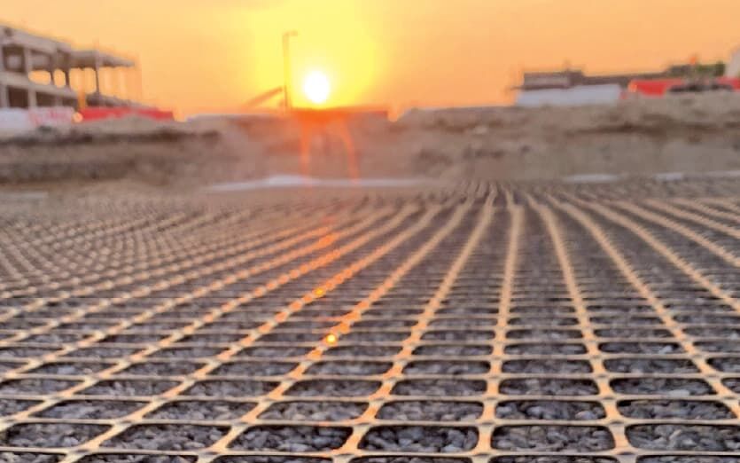 The geosynthetic, geogrid, ArmaGrid, filled with stones pictured on site at sunset.