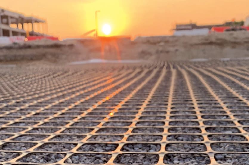 The geosynthetic, geogrid, ArmaGrid, filled with stones pictured on site at sunset.