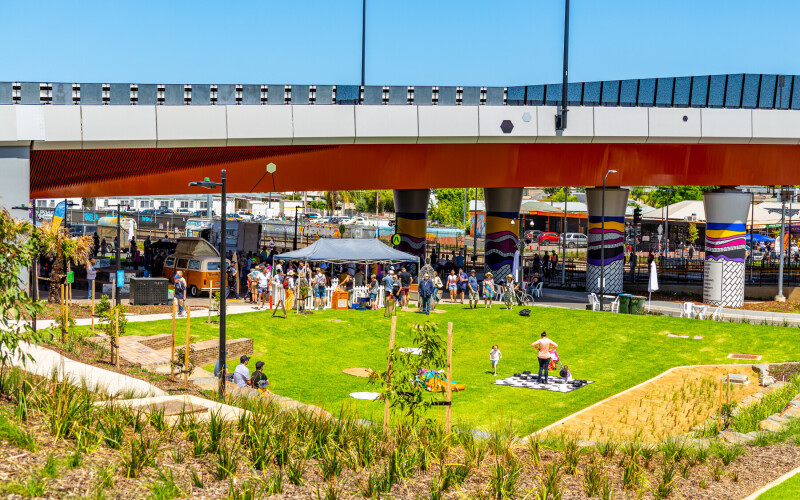 New public space at the Ovingham Level Crossing Removal Project in Adelaide, South Australia, includes gardens, ball courts and largescale mural artworks. Here children and families are pictured in the new gardens and nature play area.